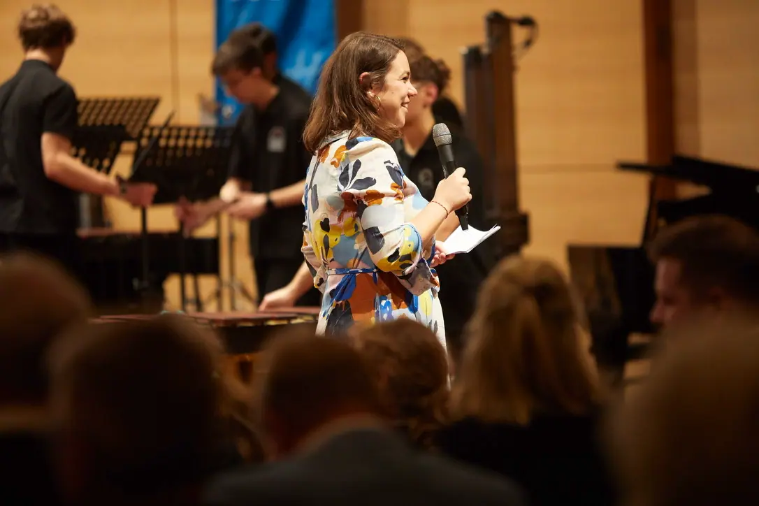 Christine Lauck speaking to an audience at a concert